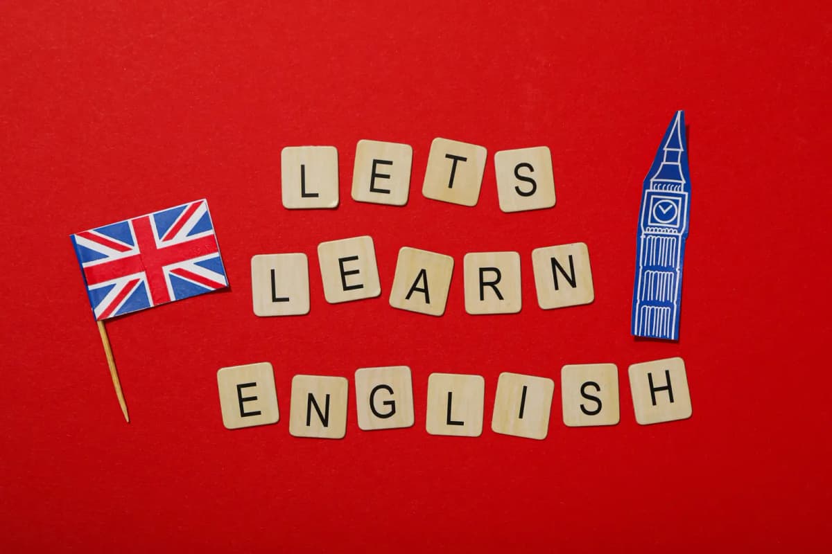 Letter tiles spelling LETS LEARN ENGLISH beside a Union Jack and a Big Ben model