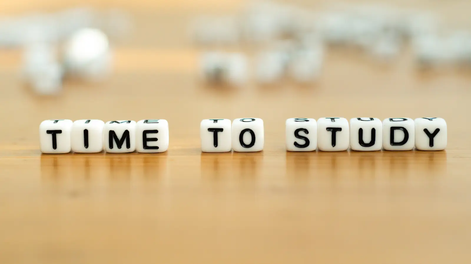 Letter blocks on a desk spelling TIME TO STUDY